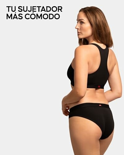 Mujer usando ropa interior negra, vista trasera.