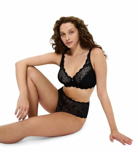 Mujer sentada con lencería negra de encaje.