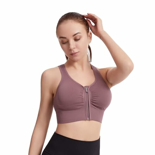 Mujer con top deportivo marrón y leggings negros.