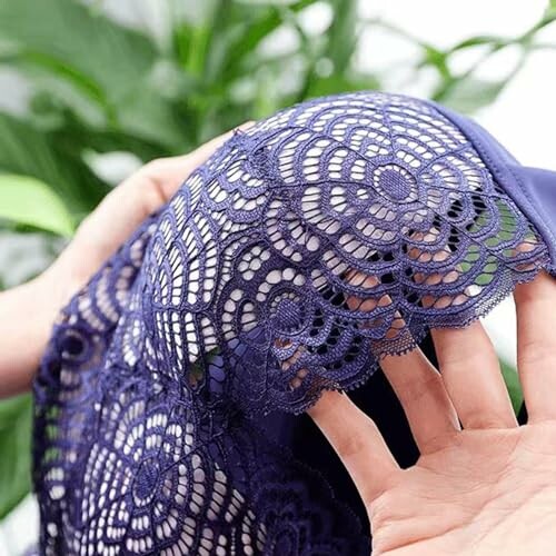 Manos sosteniendo tela de encaje morado.