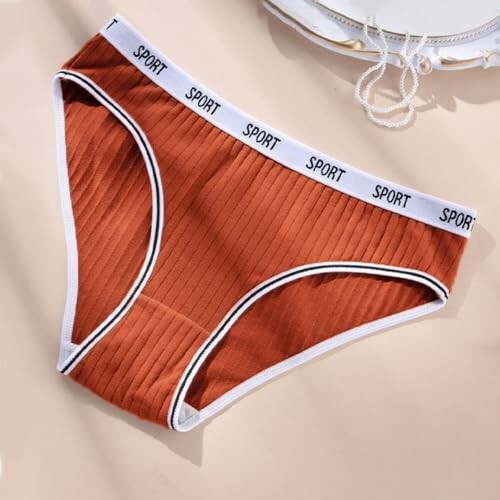 Ropa interior deportiva roja sobre fondo claro.