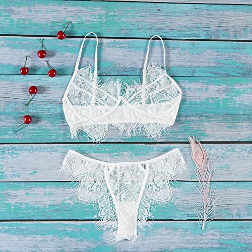 Conjunto de lencería blanca de encaje sobre fondo de madera azul.